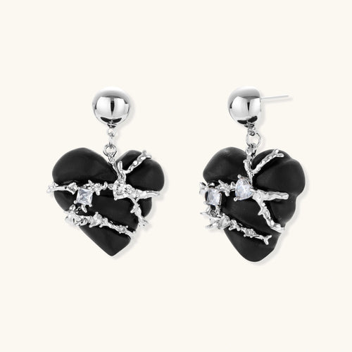 Dark ebony wood heart charms wrapped in intricate silver chains with crystal accents, shown as matching earrings and necklace set.